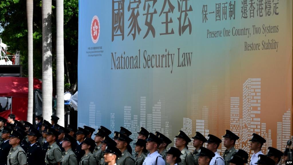 资料照:香港各种警察部队成员站在港版国安法广告牌前 (2020年7月1日)