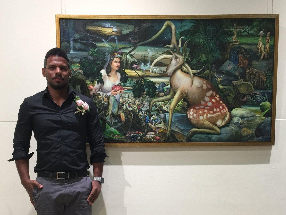 古巴畫家Reydel Espinosa與作品《禮物 The Gift》合影。記者...