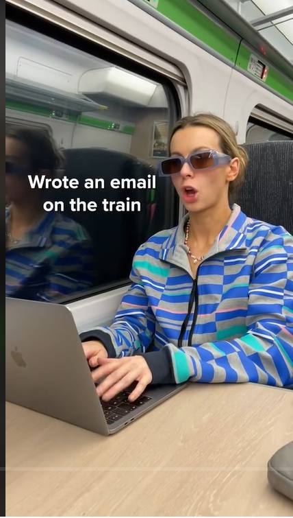 A snapshot of a social media posts showcasing a woman supposedly "writing an email on the train"