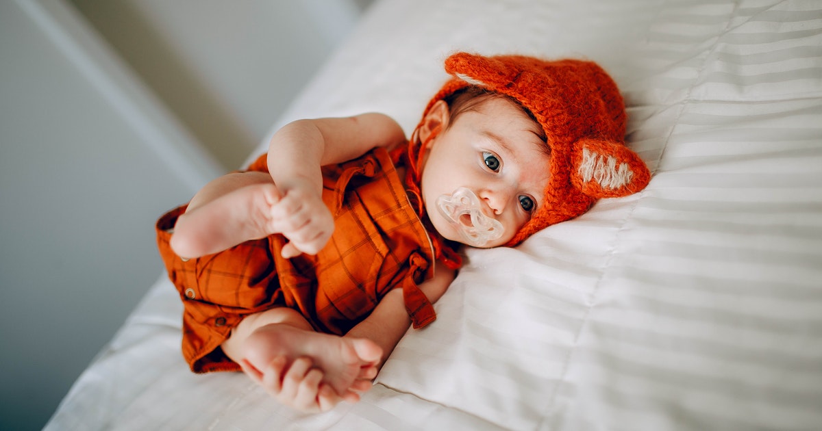 Baby with cute tiger costume sucking on pacifier 