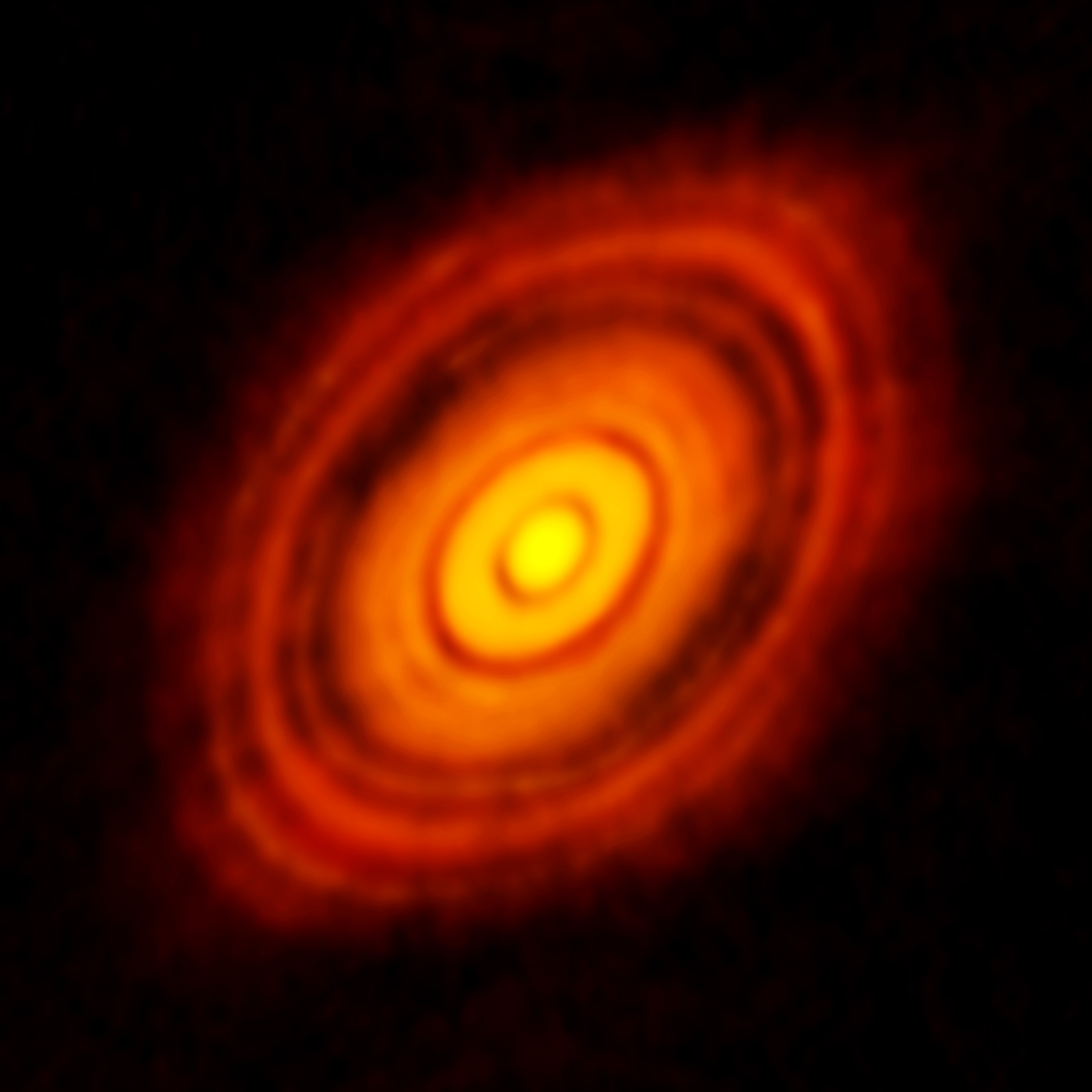 Bright orange and yellow concentric rings of a protoplanetary disk on a black background