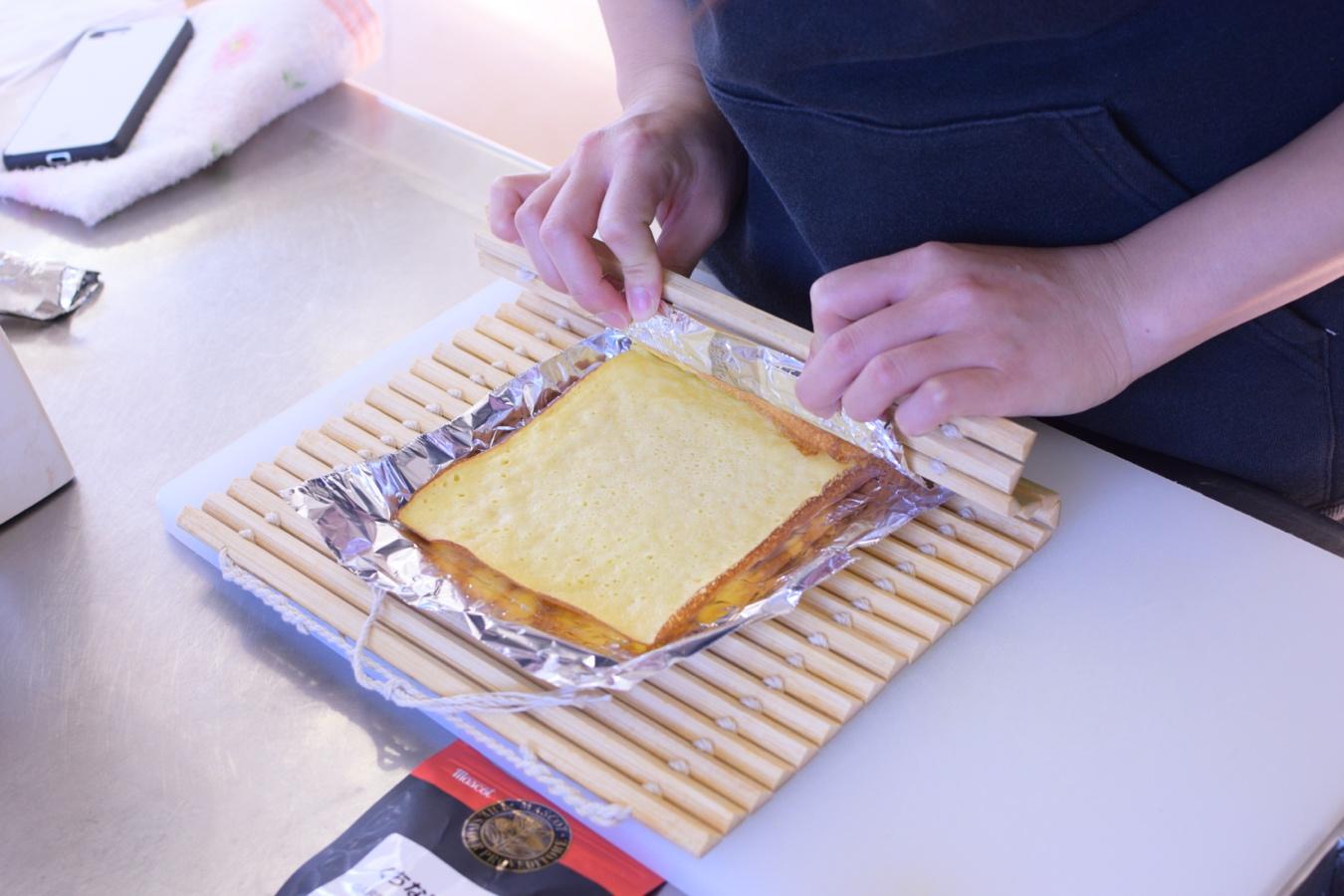 サンドイッチを切る女性  自動的に生成された説明