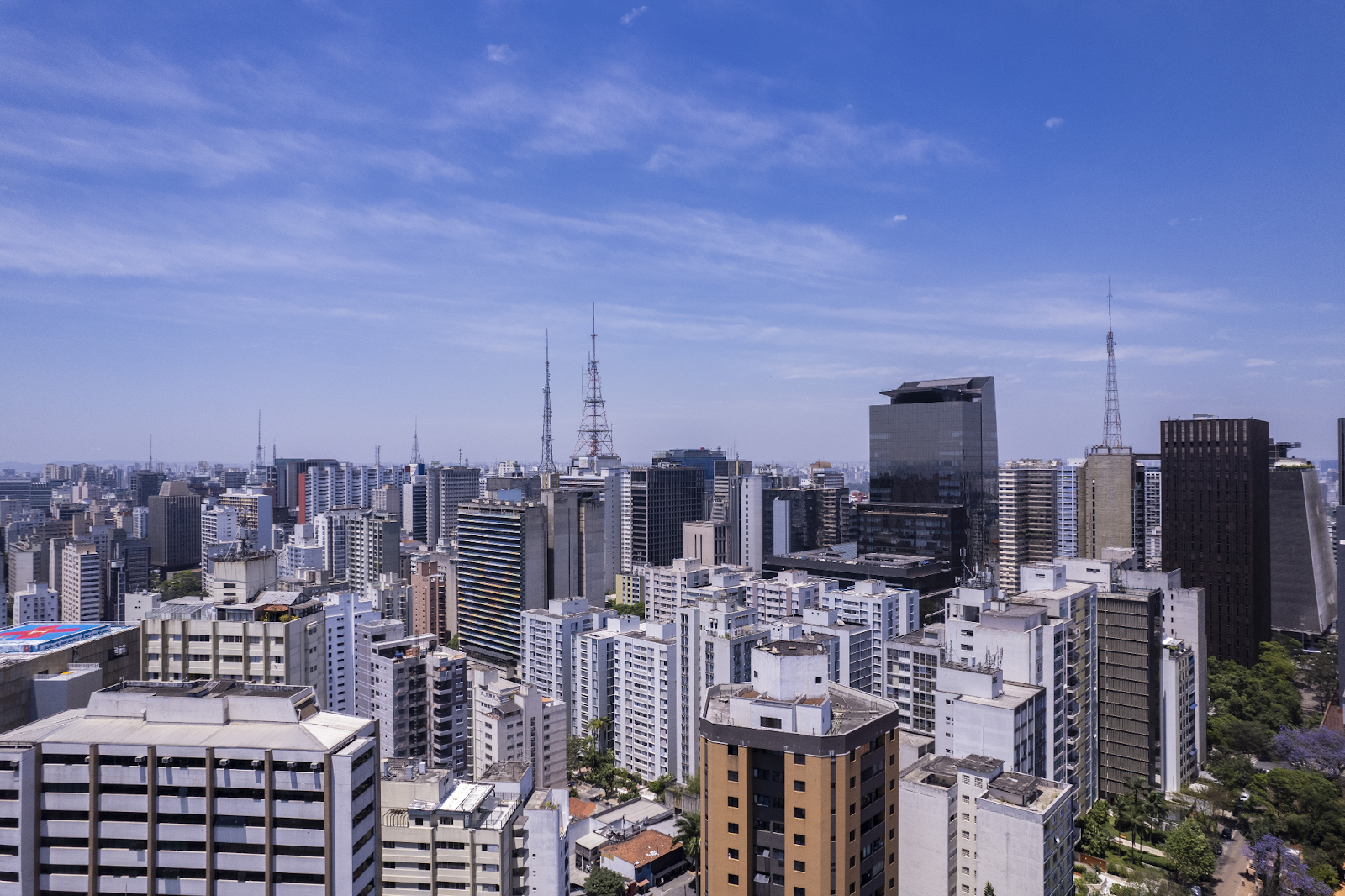 Foto panorâmica dos bairros de São Paulo, com um céu azul e muitos prédios