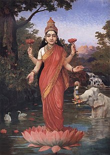 In this illustration, Devi stands on a red lotus in a lake. The goddess has multiple arms and wears a white and red sari.