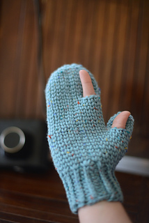 a hand wearing photography mittens