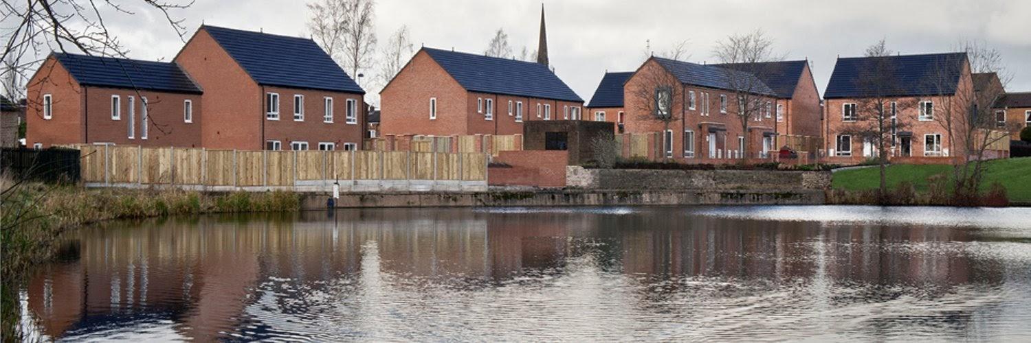 A group of houses next to a body of water

Description automatically generated with medium confidence