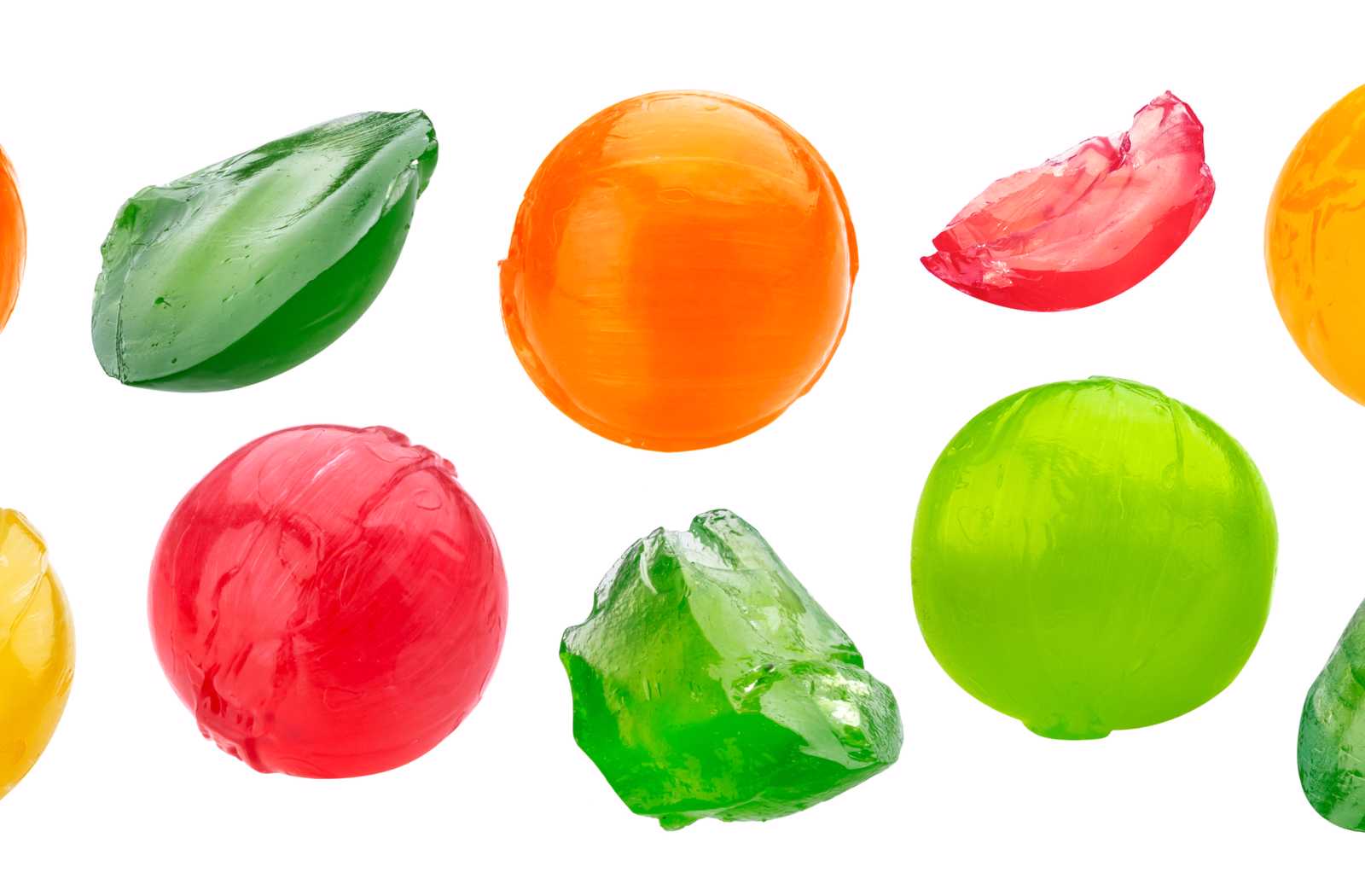 Multicoloured hard candies broken into sharp pieces on white background