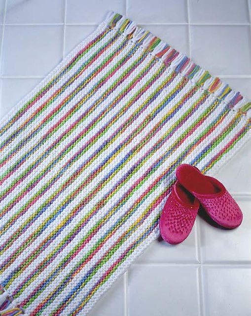 knit rug made with white and multicolored yarn on bathroom floor