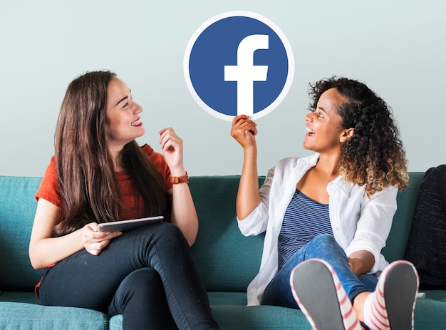 Free photo young women showing a facebook icon