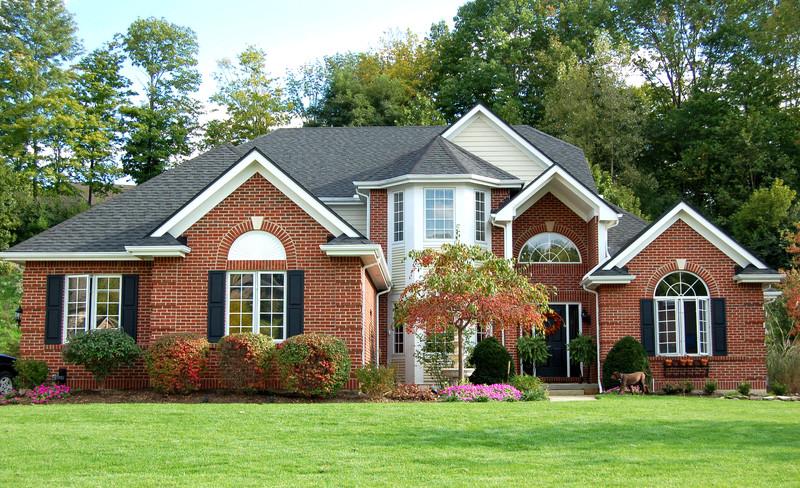 WeServe, big house made out of bricks with a green front yard filled with trees and flowers