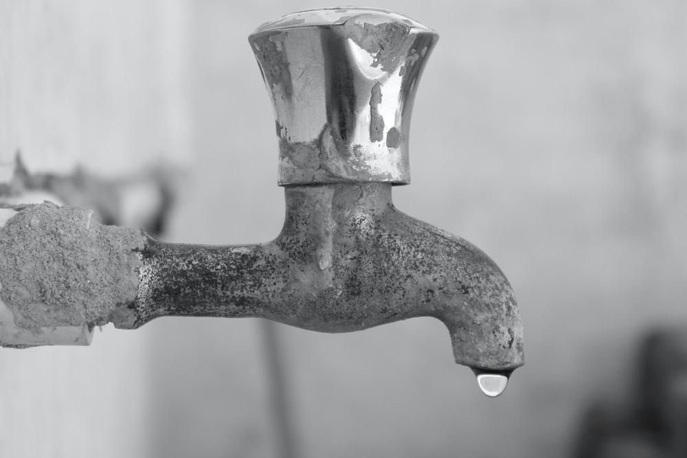 gray scale photo of faucet
