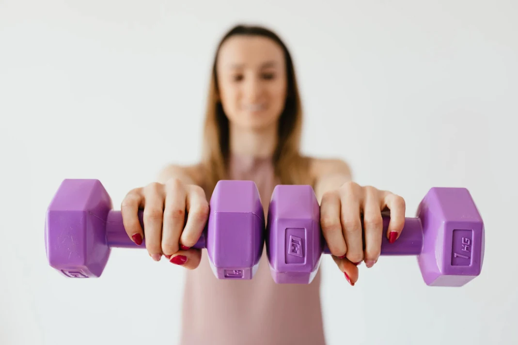 women smiling holding weights