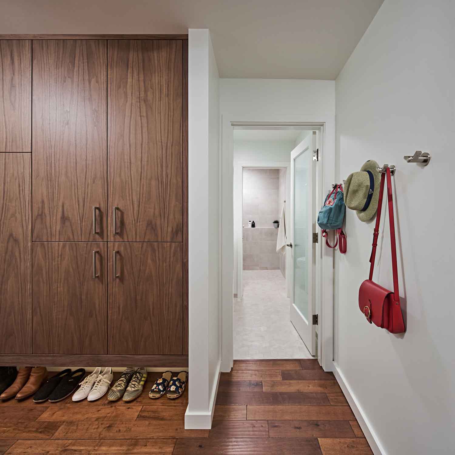 built-in brown mudroom closet with a bathroom nearby