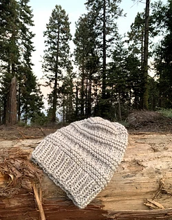 tan knit hat on wooden surface outside
