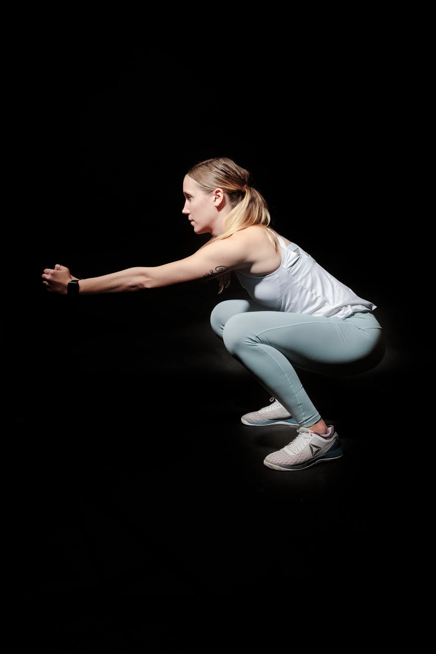 A blonde woman doing exercise in a dark room