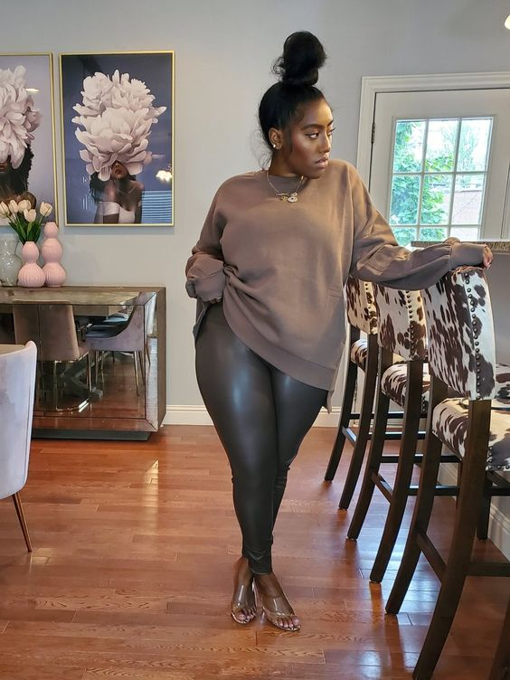 Woman wearing sweater with shiny leggings pants
