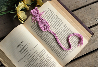 crochet bookmark shaped like a cat on top of open book