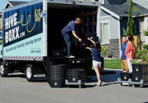 Alt-tag: People unloading a moving truck before deducting business moving expenses.