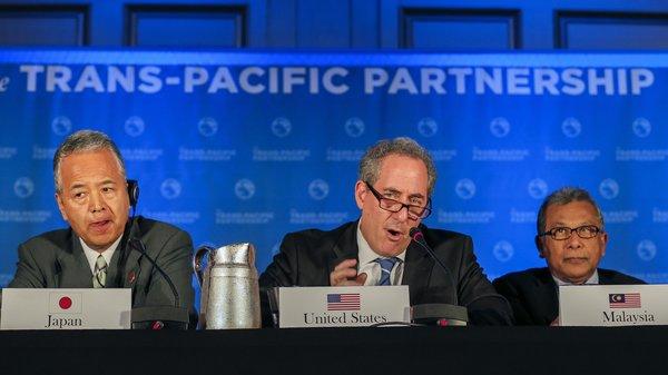 本周一在亚特兰大,美国贸易代表迈克尔·弗罗曼(中)与TPP一些成员国的贸易部长宣布了该协议。