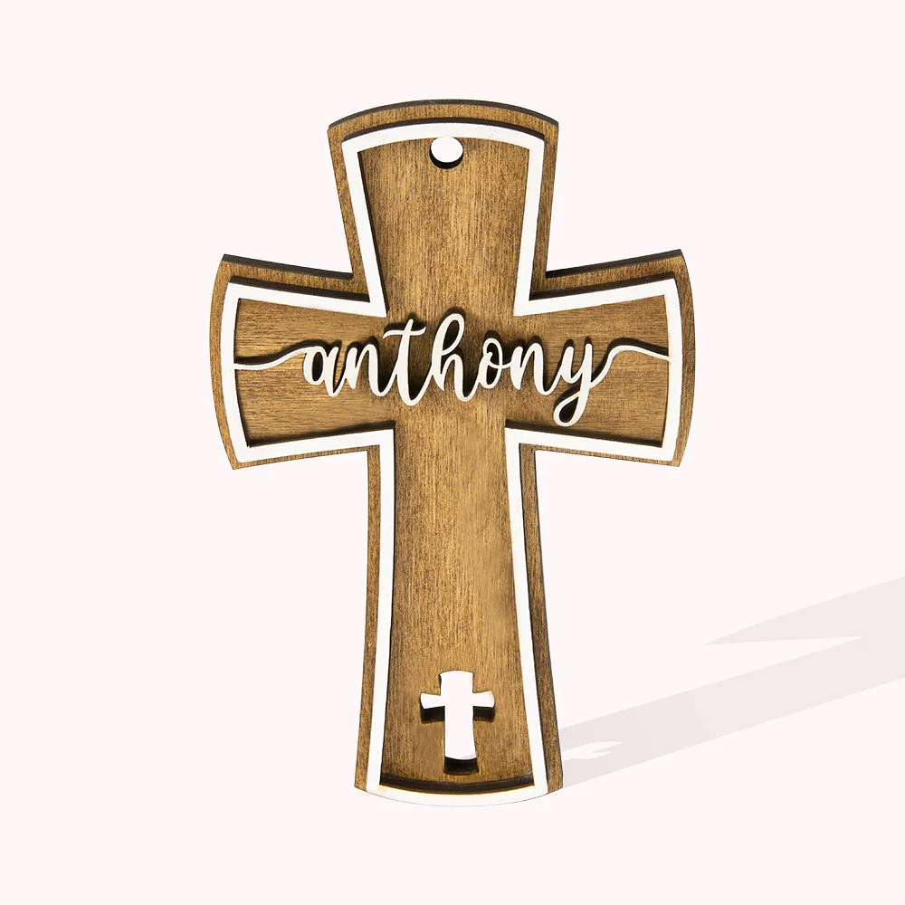 Croix chrétienne en bois avec contours blanc, percée d’une deuxième croix en bas et personnalisée par un prénom.