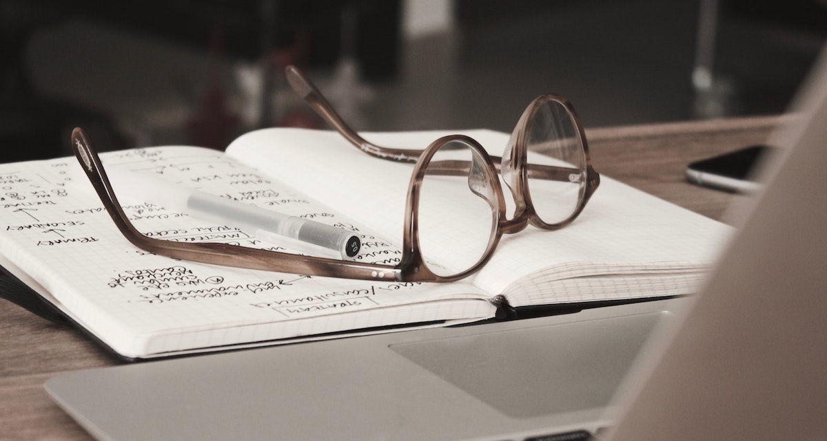 Glasses on top of a journal with numbers and writing