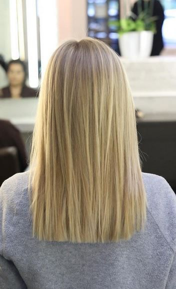 Back view of woman wearing blunt cut blond hairstyle