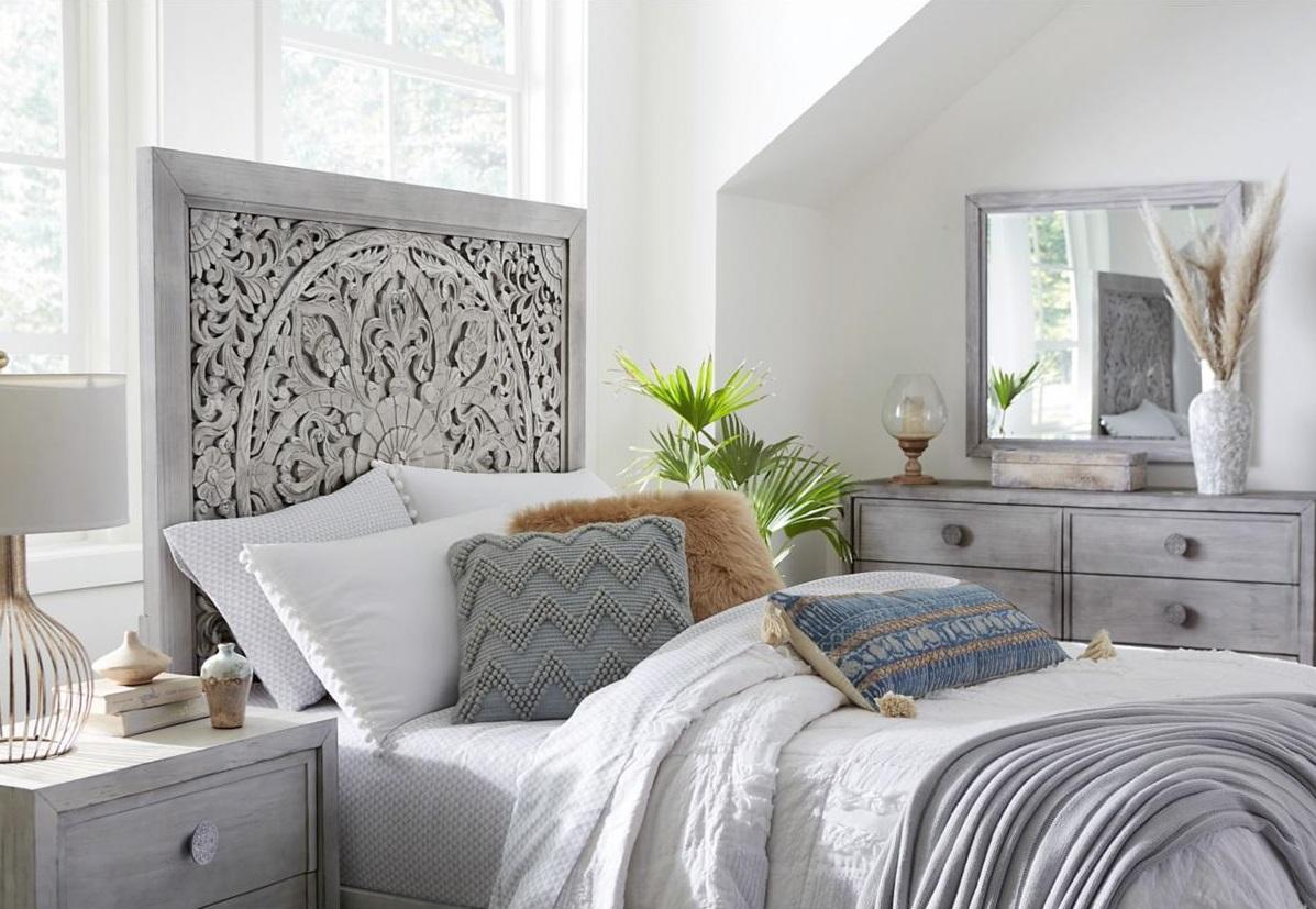A bed with an intricate headboard and cozy bedding
