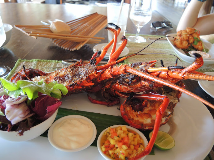 a large lobster on a plate with a side of salad and a fork