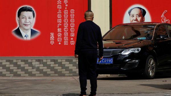 海一条街道上张贴的中国国家主席习近平和前共产党领袖毛泽东的画像。（2018年2月26日）