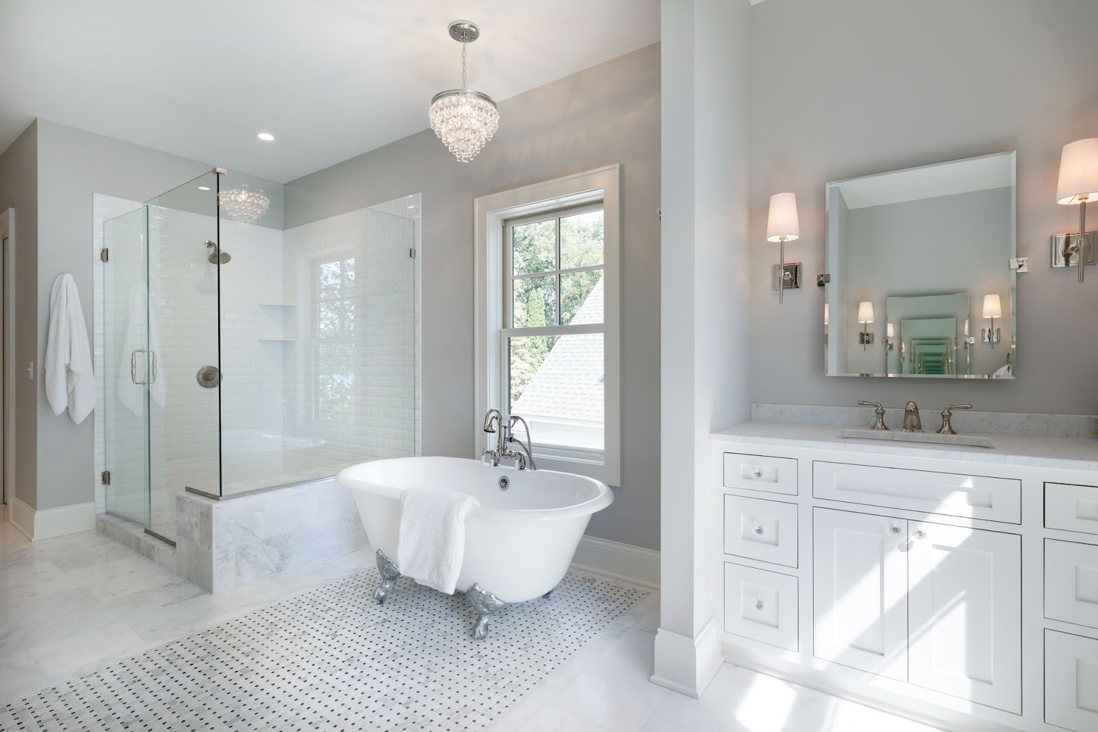 A bathroom with white tile on the floor and in the shower, with light grey walls