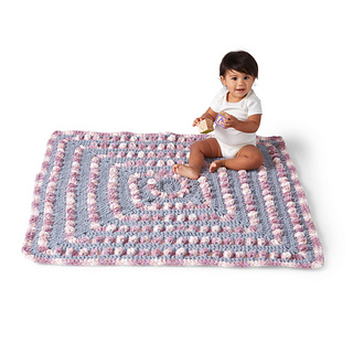 baby sitting on crochet blanket with large bobbles