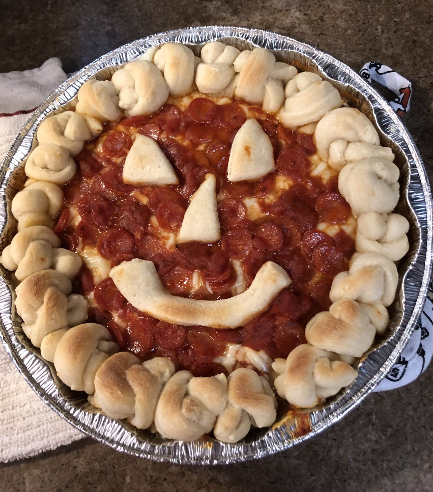 Halloween pizza dip. Jack-O-Lantern face made from pizza dip and pizza dough.