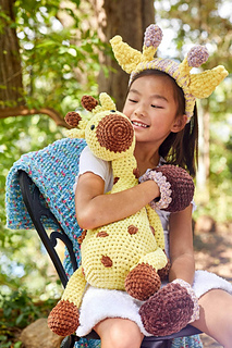 large crochet giraffe held by girl