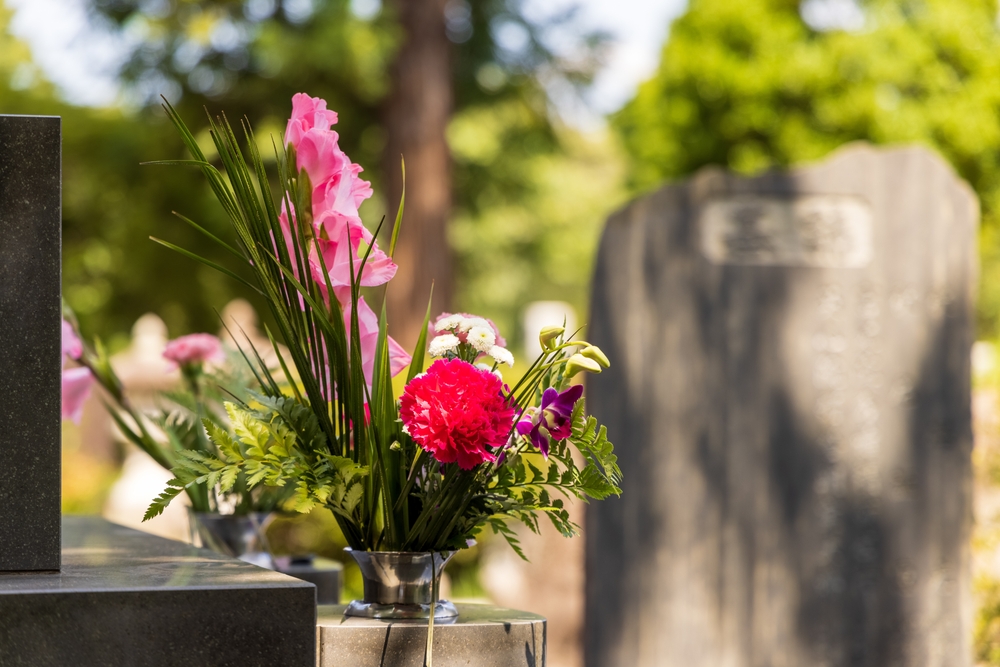 Bouquet of flowers at grave in cemetery.