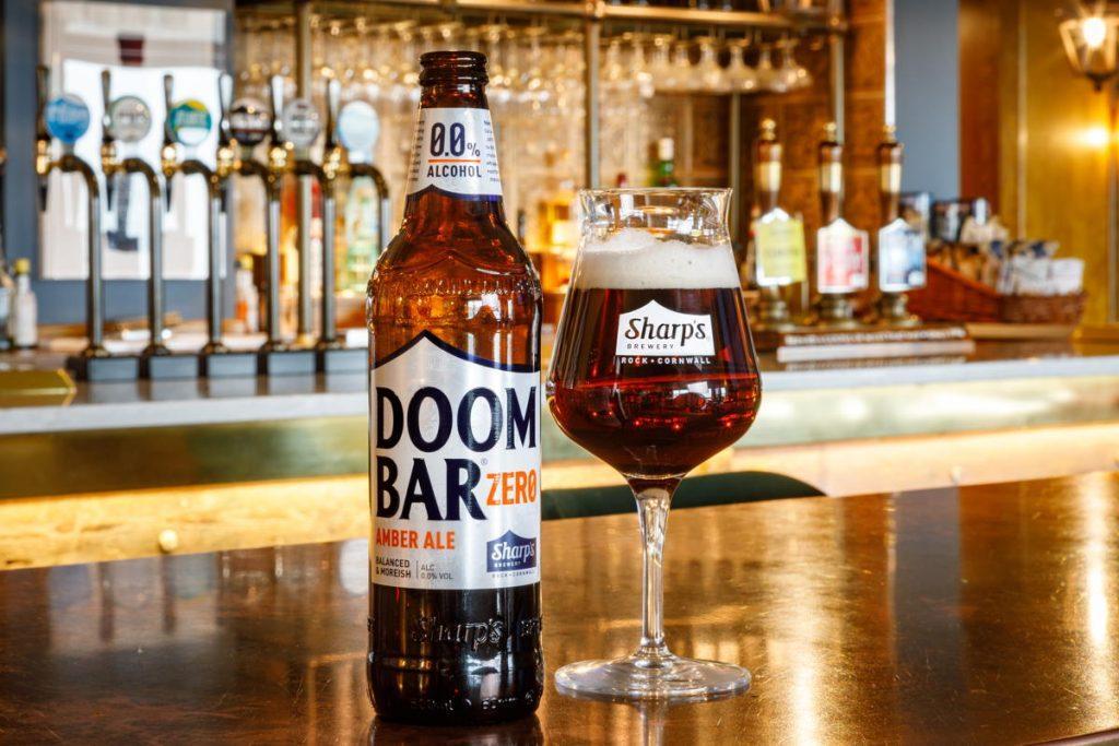 Doom Bar Zero Alcohol Amber Ale bottle and glass sitting on a bar in a pub