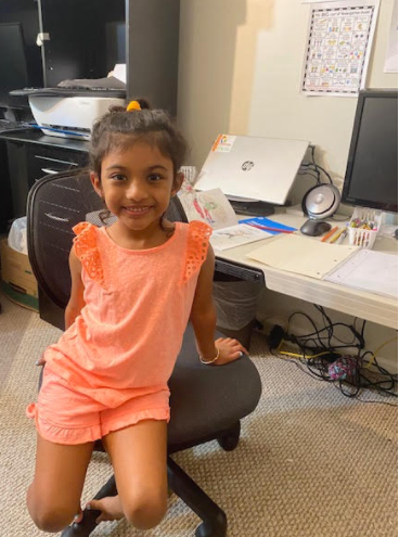 young smiling student sitting in office chair at desk