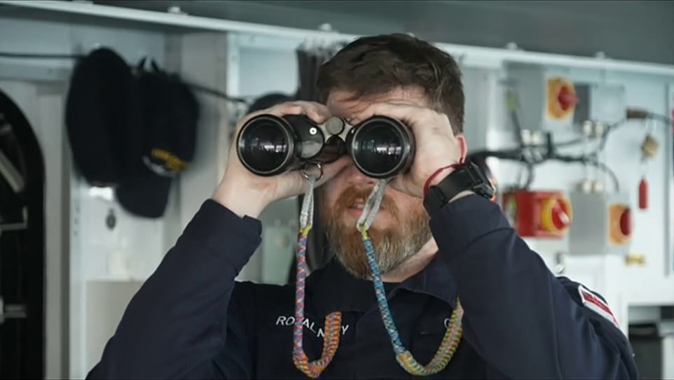 Vigilance: Crew member scans sea for Russian activity on board the vessel on Tuesday when the incident occured