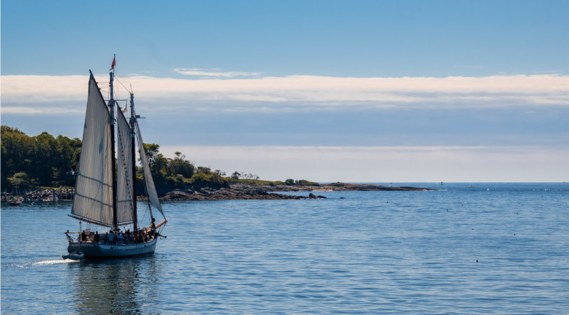 A sailboat cruising along the coast of Peaks Island