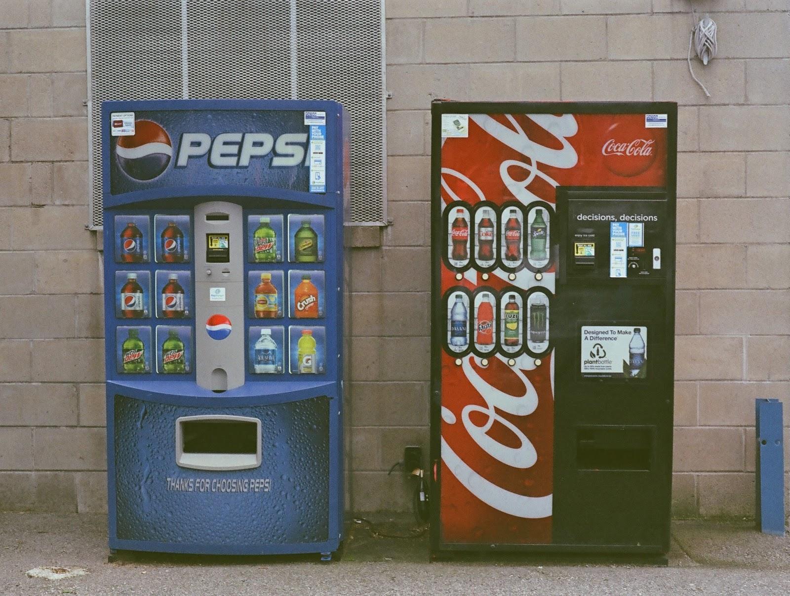 coke vending machine next to a pepsi vending machine