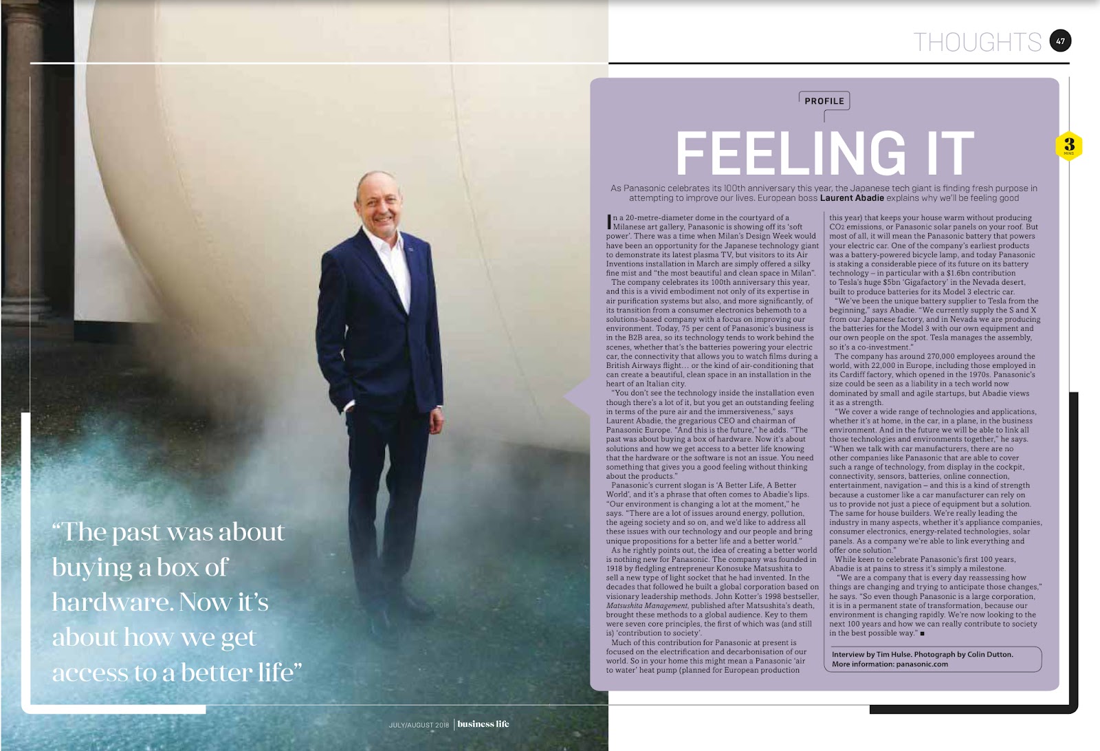 A tearsheet from Business Life magazine showing a business man standing in an industrial setting. He is wearing a navy suit and a big smile.
