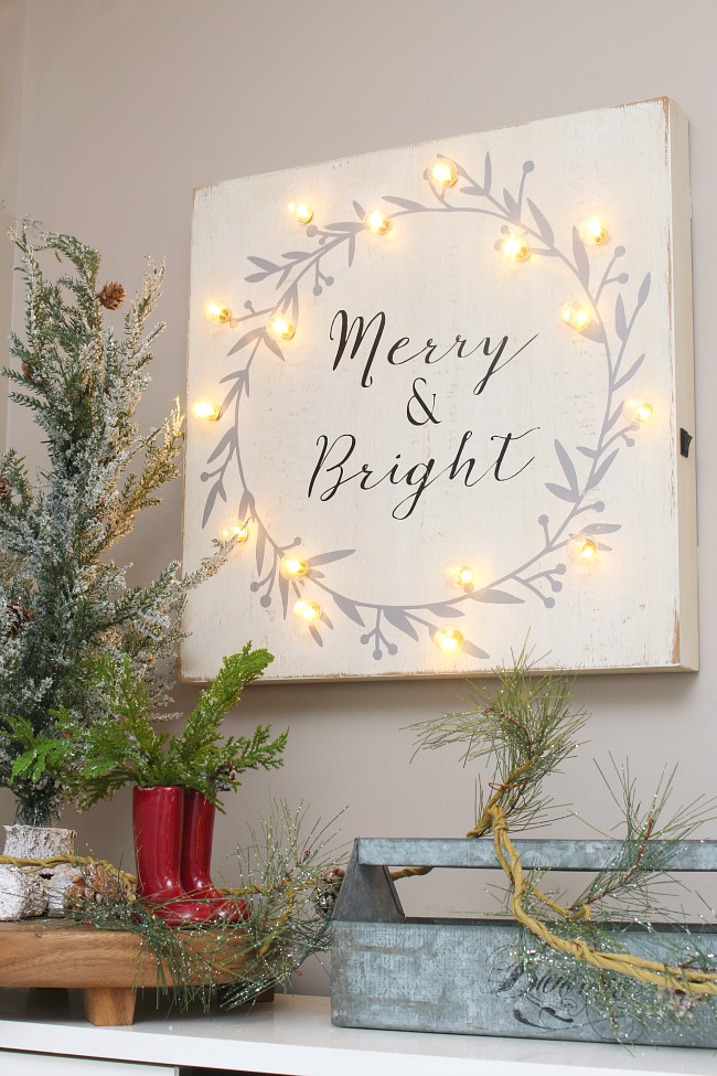 Merry and Bright wood sign with lights in a Christmas front entry.