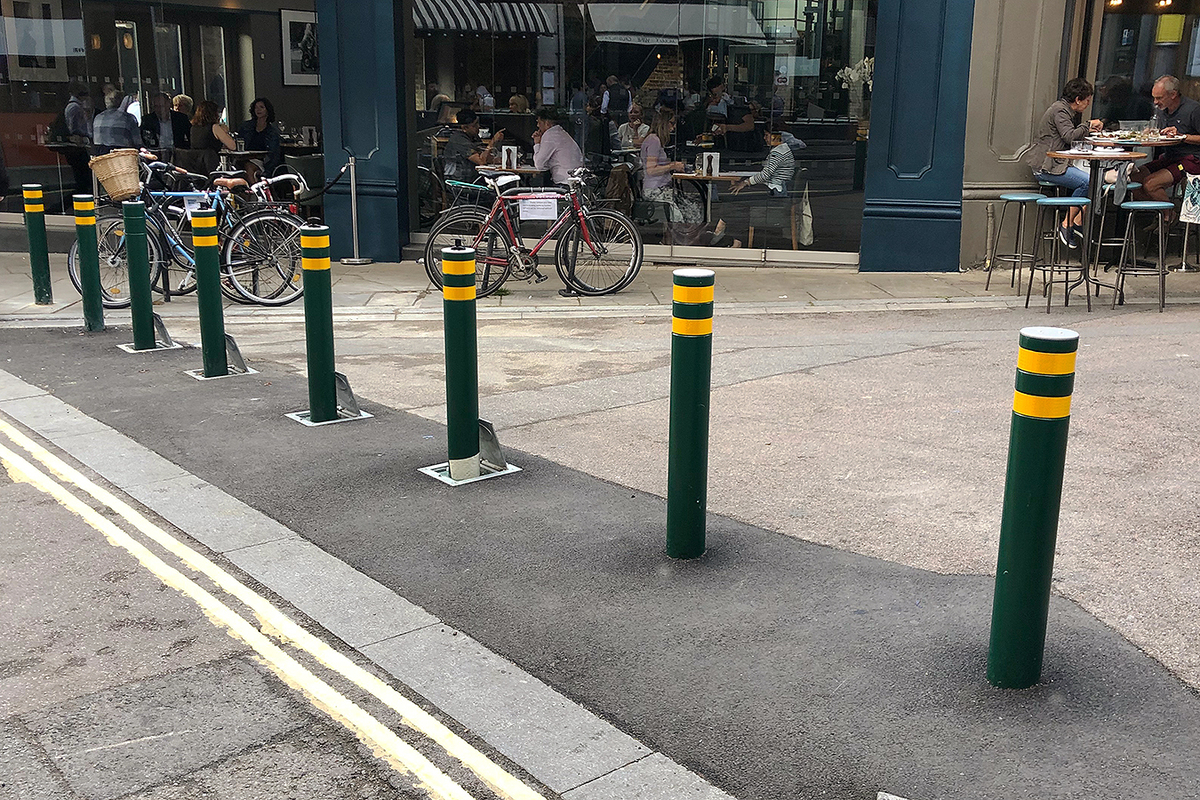 Crash rated SP100 LA retractable bollards shown in a public space to protect cafes, restaurants and pedestrians from vehicles.