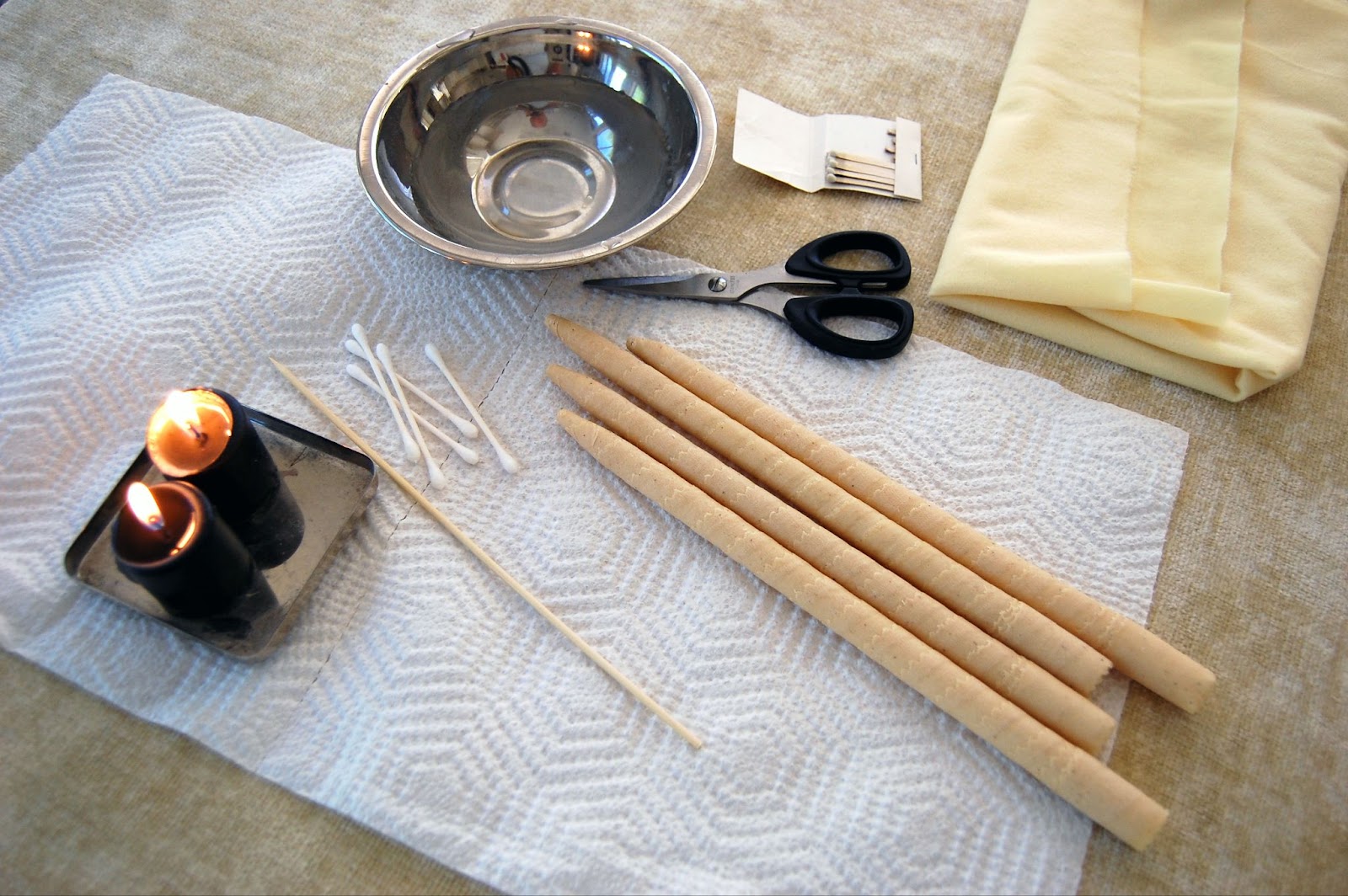 A selection of hopi ear candling tools including candles, scissors, ear buds, and matches.