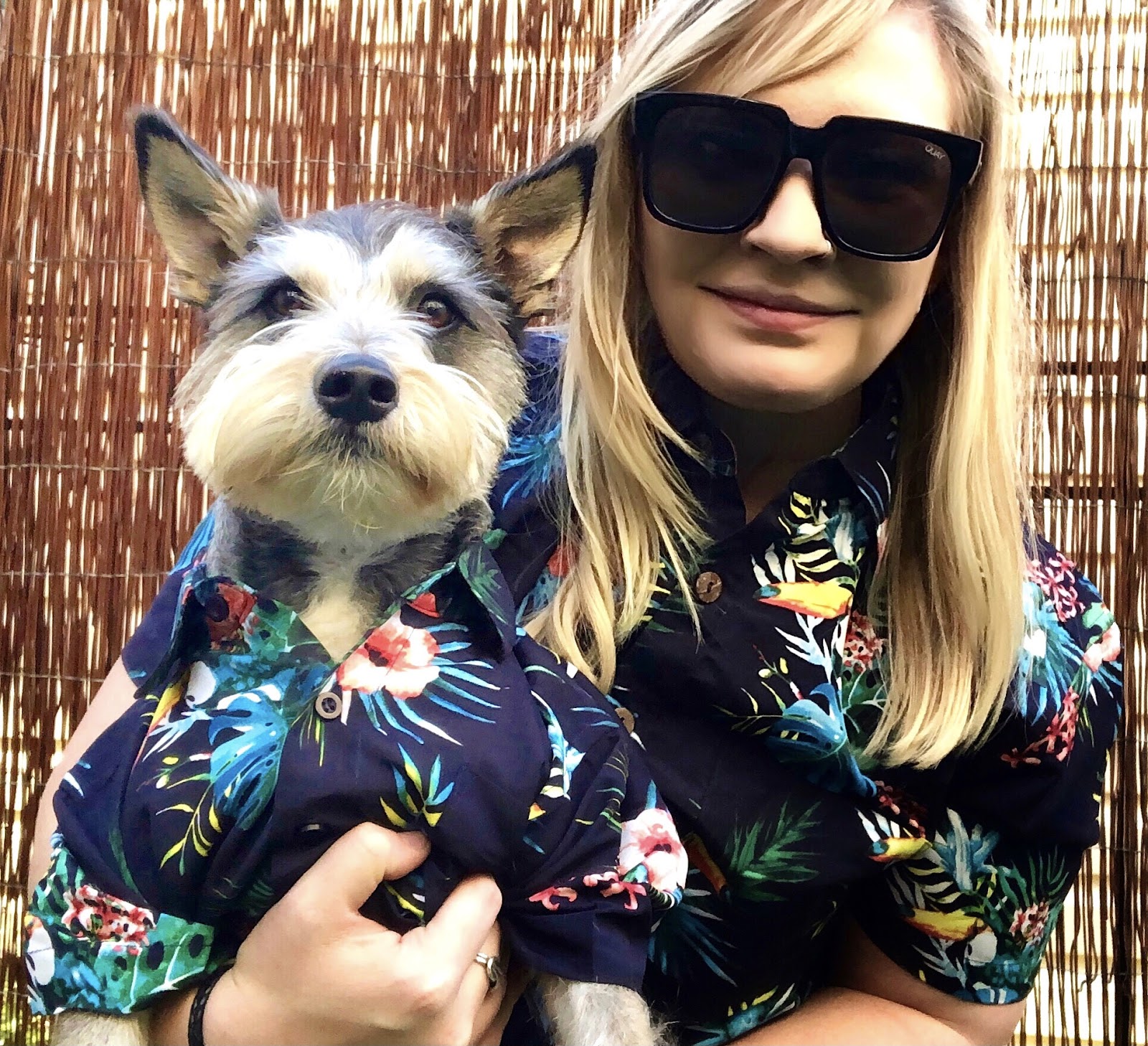 girl and small dog dressed up in hawaiian shirts