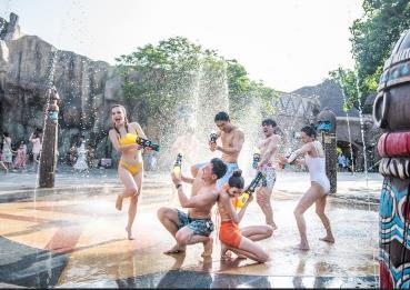 A group of people playing with water guns Description automatically generated