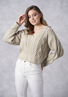 woman wearing a cropped cable knit v neck sweater