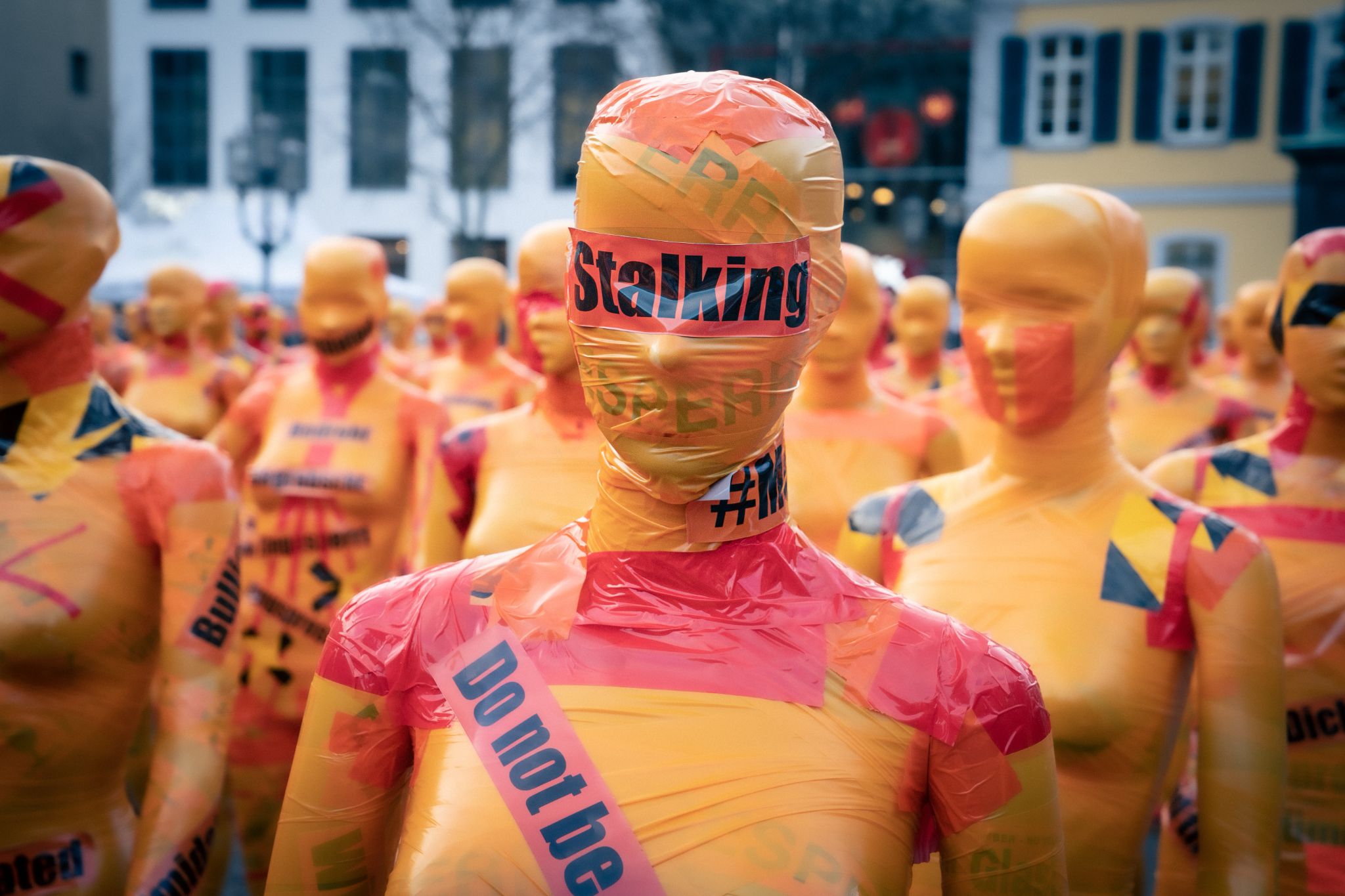 A group of dummy mannequins wrapped in cautionary tape