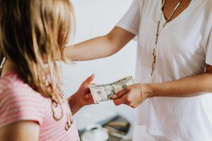 a mother teaching kids about money management by giving an allowance for chores