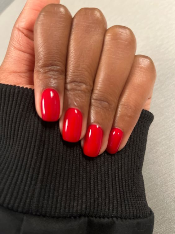 Lady  shows off her beautiful red nails, a gorgeous sample of a cute short nails