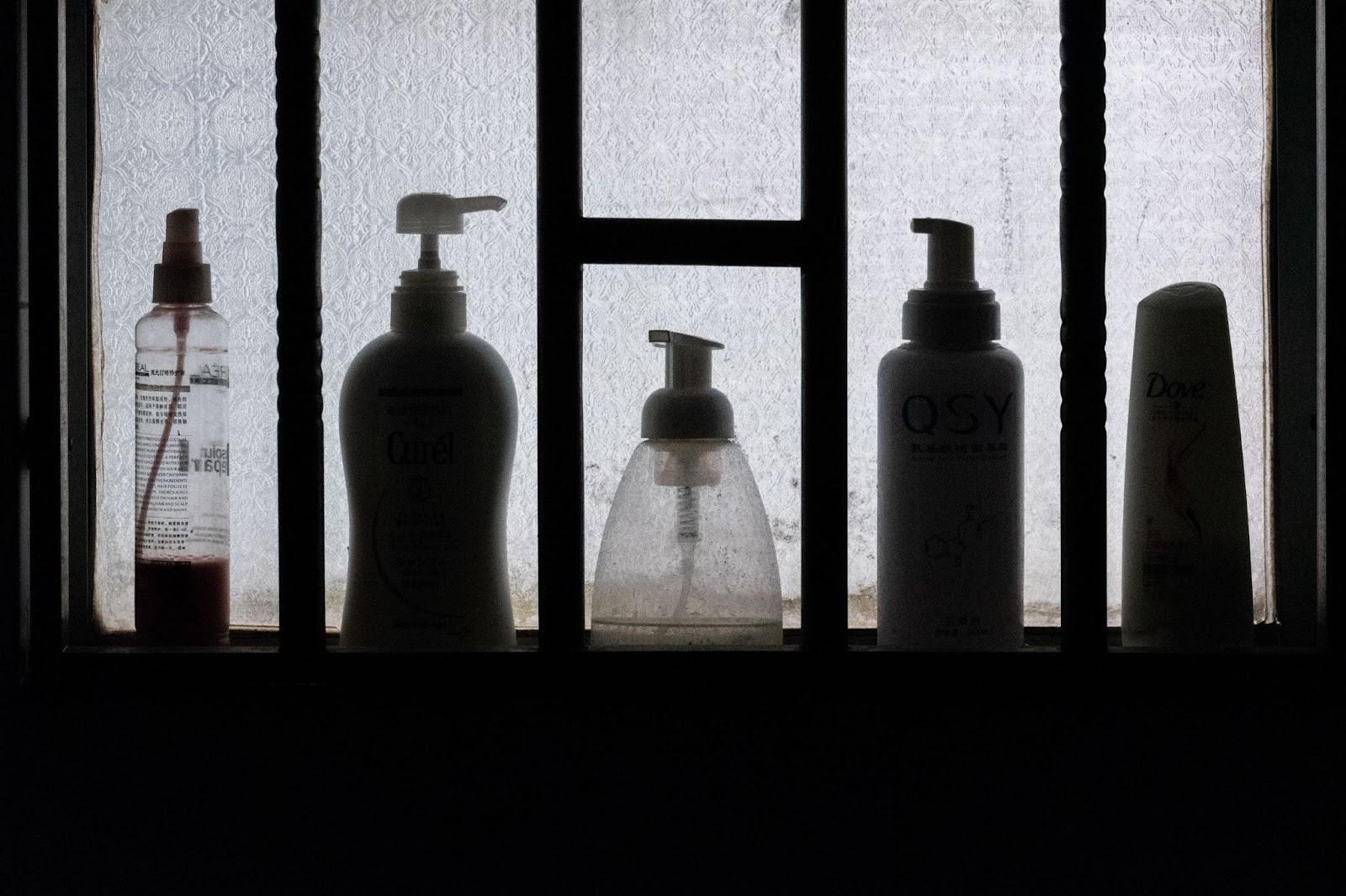 toiletries lined up in front of a window